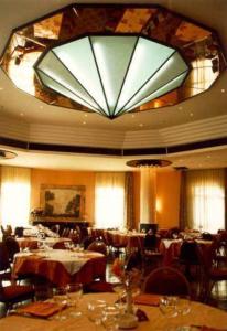 卡利特里安博夏朵利酒店的一个带桌子和大吊灯的大型用餐室