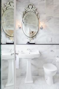 科克The Metropole Hotel Cork的浴室设有两面镜子、盥洗盆和卫生间。