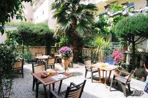 圣马克西姆勒沙尔登布鲁酒店的庭院设有木桌、椅子和鲜花