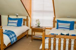 帕尔The Orange Bowl的卧室内的两张床,配有蓝色和白色枕头