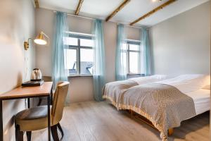 博尔加内斯英格伦丁加维民宿的一间卧室配有一张床、一张书桌和两个窗户。