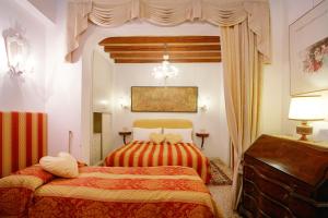 威尼斯San Luca Flats的一间卧室配有两张床和吊灯。