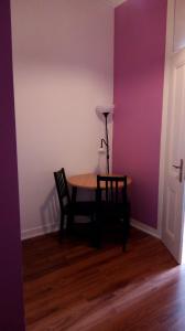 里斯本塞纳里奥卡迪塔旅舍的紫色墙壁的房间里一张桌子和椅子