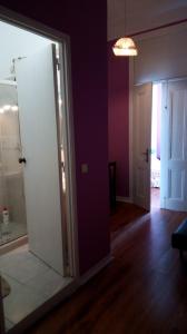 里斯本塞纳里奥卡迪塔旅舍的通向带紫色墙壁的房间的开放式门