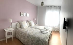 潘普洛纳伊鲁尼公寓的白色的卧室设有床和窗户