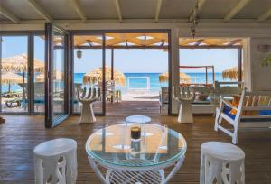 库卡里Kokkari Beach Hotel的一间设有玻璃桌和椅子的客房,以及海滩