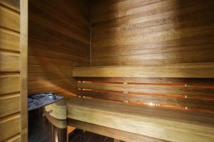 派尔努Dönhoff Residence的一间带木墙和木板凳的桑拿浴室