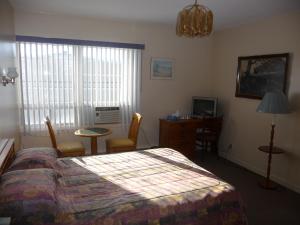 格雷斯港格雷斯港酒店的一间卧室配有一张床、一张桌子和一张书桌
