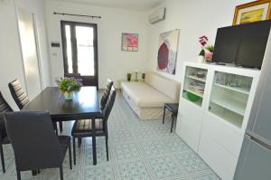 莱乌卡Casa Baia smeraldo的客厅设有餐桌和沙发