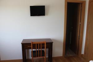 罗德里戈城汨罗布里加旅馆的桌子、椅子和墙上的电视