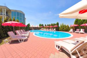 斯梅代雷沃Hotel Dragović Smederevo的一座带椅子和遮阳伞的游泳池位于一座建筑旁边