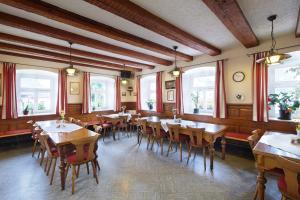 丁克尔斯比尔Gasthof Goldenes Rössle的餐厅设有木桌、椅子和窗户。