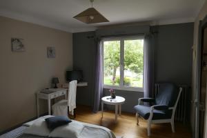 潘波勒Chambres d'hotes chez laure & François的一间卧室配有一张床、一张书桌和一个窗户。