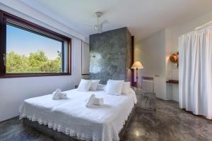 卡拉塔瑞达肯阿祖尔别墅酒店的一间卧室配有一张带白色床单的床和一扇窗户。