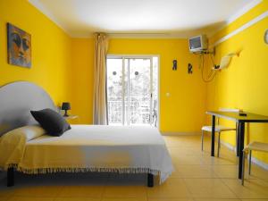 萨洛雷克斯公寓的黄色的卧室设有床和窗户