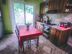 杜布罗夫尼克Anchi Guesthouse的厨房配有红色桌子和红色的桌椅
