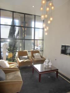 圣地亚哥拉潘西奥尼酒店的客厅配有两把椅子和一张茶几