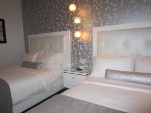 圣地亚哥拉潘西奥尼酒店的一间卧室设有两张床,墙上有图案。