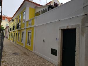 塞图巴尔Casa Visconde de Alcácer的街道上一排黄色和白色的建筑