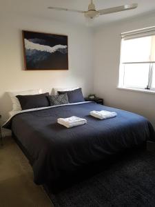 巴瑟尔顿FortyOne - Oceanside Retreat Busselton的一间卧室配有一张大床和两条毛巾