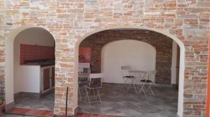 塔瑙内拉Residenza Vacanze的一间设有砖墙、椅子和桌子的房间