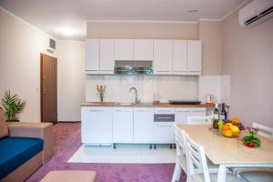 维尔卡瑟Apartamenty Niegocin的厨房配有白色橱柜和水果桌