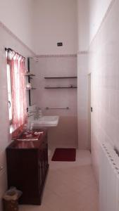 布林迪西Casa Millenovecento的白色的浴室设有水槽和镜子