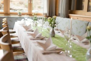 圣科卡瑟林奥夫安特贝尔格酒店的一张长桌,上面有白色的餐巾纸和鲜花