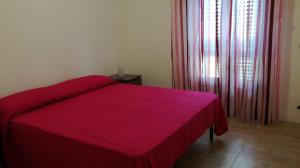 米内尔维诺迪莱切Appartamento vacanze da "Nonna Zoraide"的卧室里一张红色的床罩