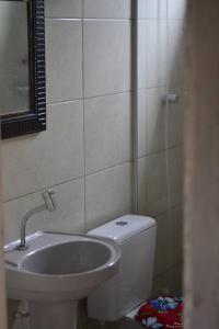 普腊亚罗萨Hostel Quintal do Rosa的一间带卫生间和水槽的浴室