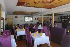 贡迪温迪麦金太尔汽车旅馆的餐厅配有白色桌子和紫色椅子