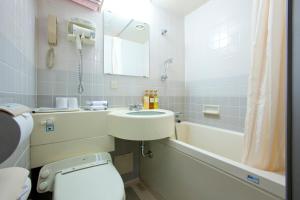 滨松滨松埃斯特酒店的浴室配有盥洗盆、卫生间和浴缸。