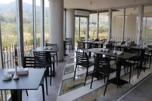 拜特龙Le Six Hotel And Resort的餐厅设有桌椅和窗户。