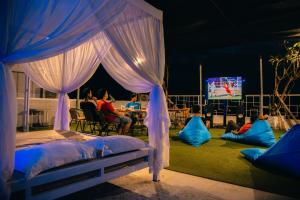 克罗柏坎德瓦巴厘岛公寓式酒店的一间卧室设有一张天蓬床,客人可以观看电视。