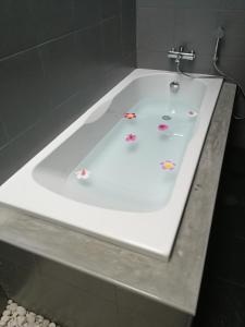 清迈M.I.N.D.别墅公寓-SHA Plus的白色浴缸内装有鲜花