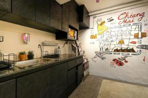 清迈萨利旅舍的厨房配有水槽和带画的墙壁