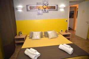 切萨雷奥港Villa Marzia的一间卧室配有黄色的床和毛巾