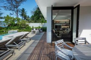 芭东海滩Rosewood Phuket的一个带桌椅的户外庭院和一间客厅