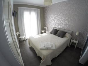 滨海托萨地中海旅馆的卧室配有白色的床和窗户。