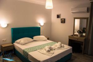 波罗斯Cielo Apartments的一间卧室配有一张带蓝色床头板和镜子的床