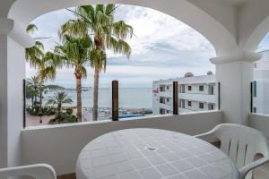 圣埃乌拉利亚罗斯公寓式酒店的阳台配有桌子,享有海景。