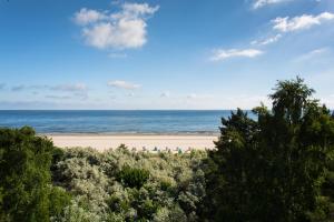 塞巴特阿尔贝克塞西洛彻别墅酒店的享有树木繁茂的海滩和大海的景致。