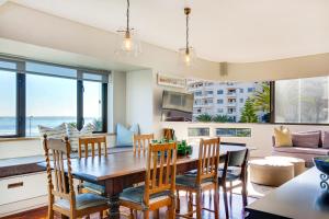 开普敦Backup Powered Sea View Apartment on the Promenade的用餐室以及带桌椅的起居室。