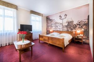 托伦格泰科酒店的卧室配有一张床,墙上挂有绘画作品