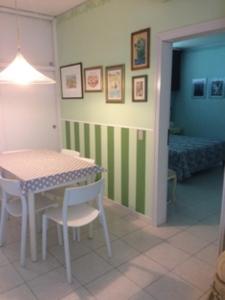 毕博纳的码头Marina Di Bibbona的一间带桌椅的用餐室和一间卧室