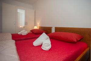 斯普利特Apartment Ana的两张带红色床单和白色毛巾的床