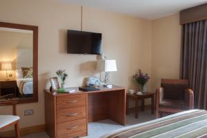 莫纳汉四季酒店及休闲俱乐部的酒店客房设有一张床和一个带镜子的梳妆台