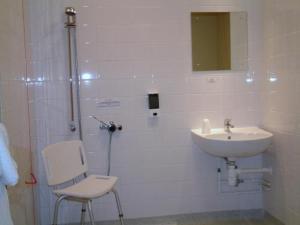 罗瑟勒姆迎宾罗瑟勒姆/谢菲尔德酒店的带淋浴、水槽和椅子的浴室