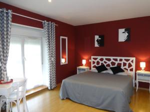 Val de VesleLes chambres d'hôtes Joy的卧室设有红色的墙壁、一张床和窗户