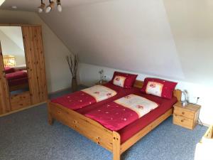 博尔滕哈根Ferienhaus Kira的一间卧室配有一张大木床和红色床单